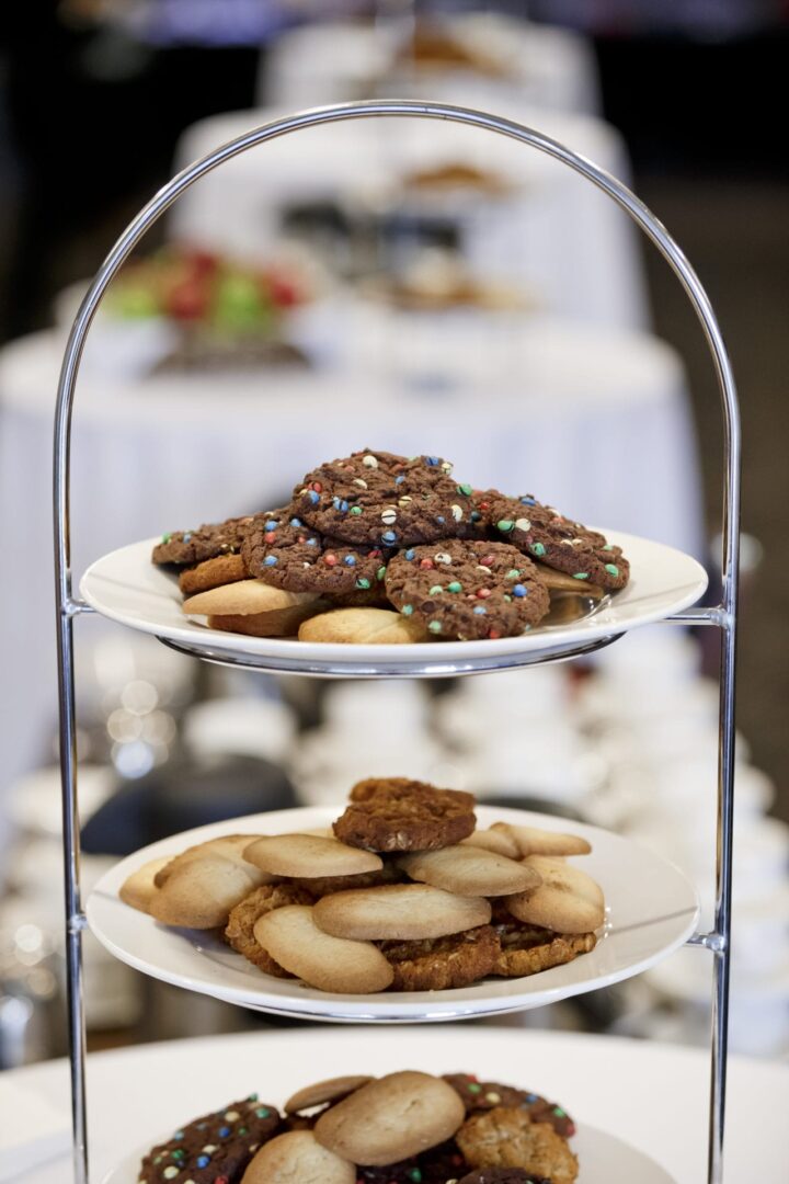 A three tiered plate with cookies on top of it.