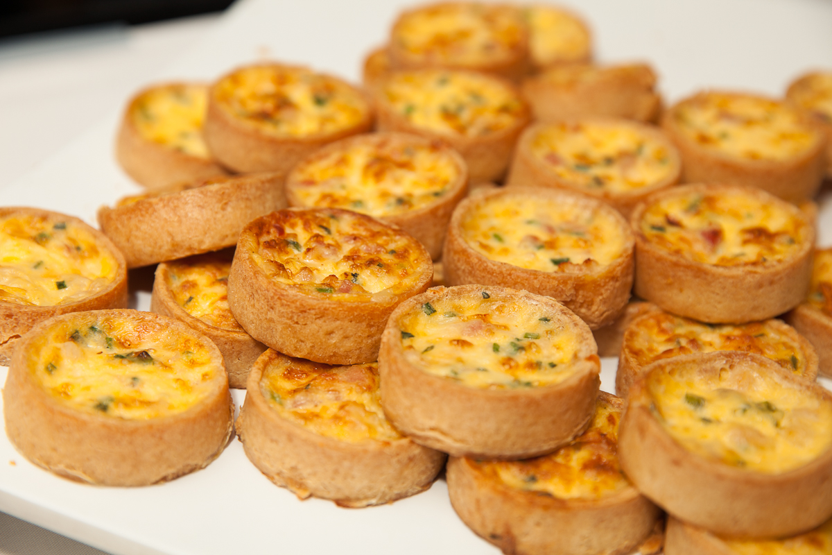 A plate of mini quiche on top of a table.